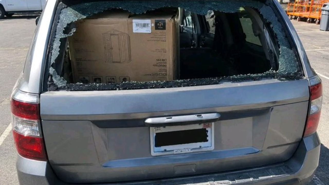 Shattered SUV window after a boxed shed shifted during drive home, driver says.