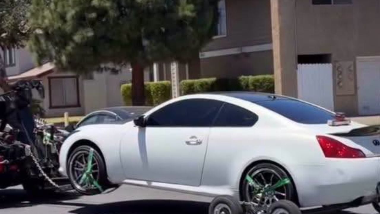 White Infiniti loaded onto a tow truck after Santa Ana Police seized the vehicle during a World Cup celebration investigation.