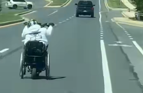 man in motorized wheelchair on road