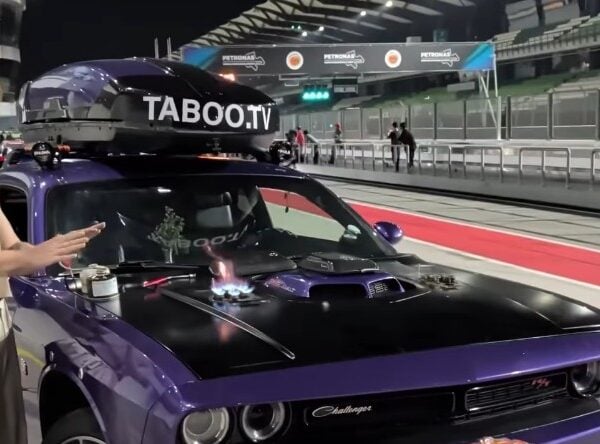 Man Showers at an F1 Circuit Using a Dodge Challenger’s Trunk — There’s Also a Stove on the Hood