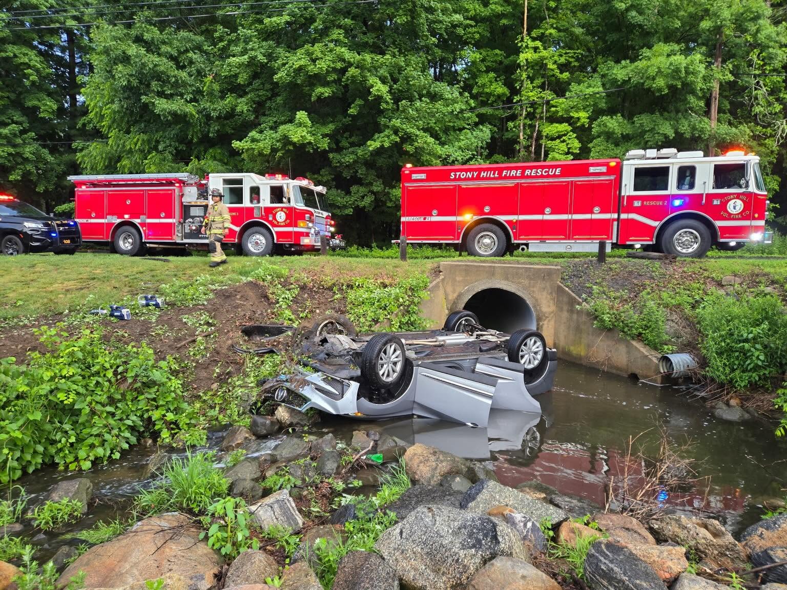 Overturned car partially submerged in a river after crashing off the roadway in Bethel, Connecticut.