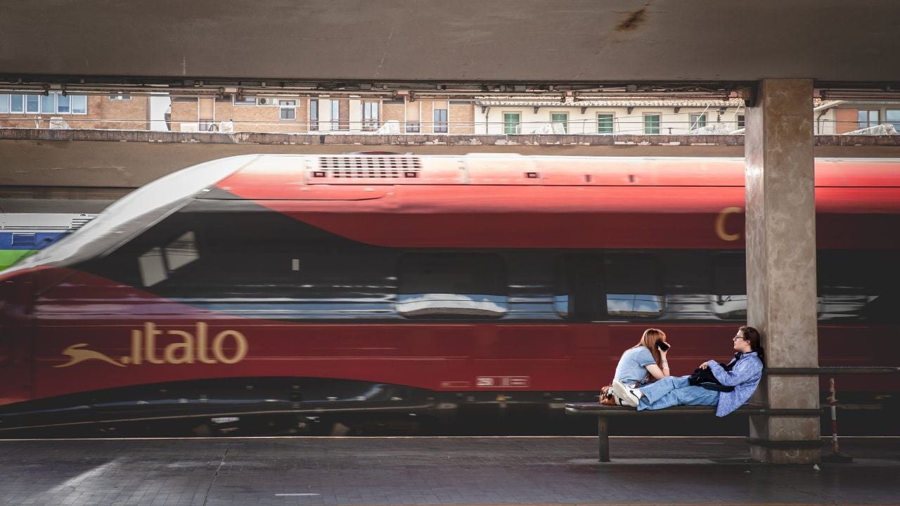 Florence, Italy - June 15, 2024 - Travelers at Santa Maria Novella station as an Italo train passes