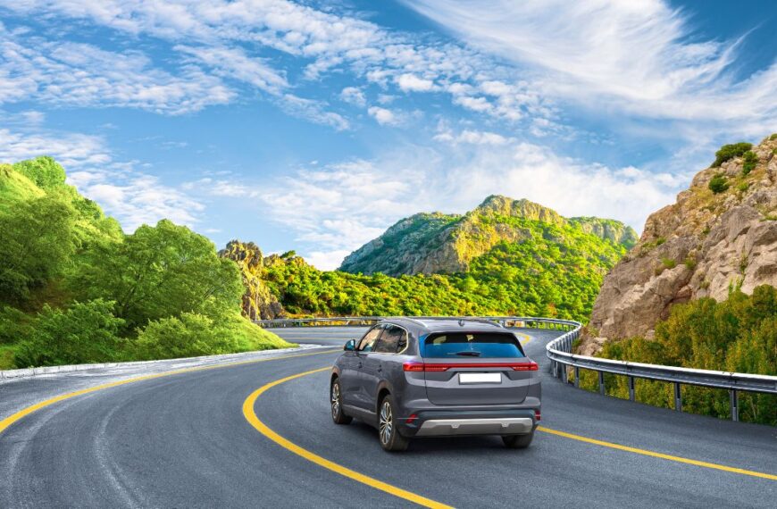 Electric car drive on nature road between green mountains in summer. Nature landscape on highway for summer vacation travel. Mountain road view on beautiful nature trip in Europe. car drive on highway