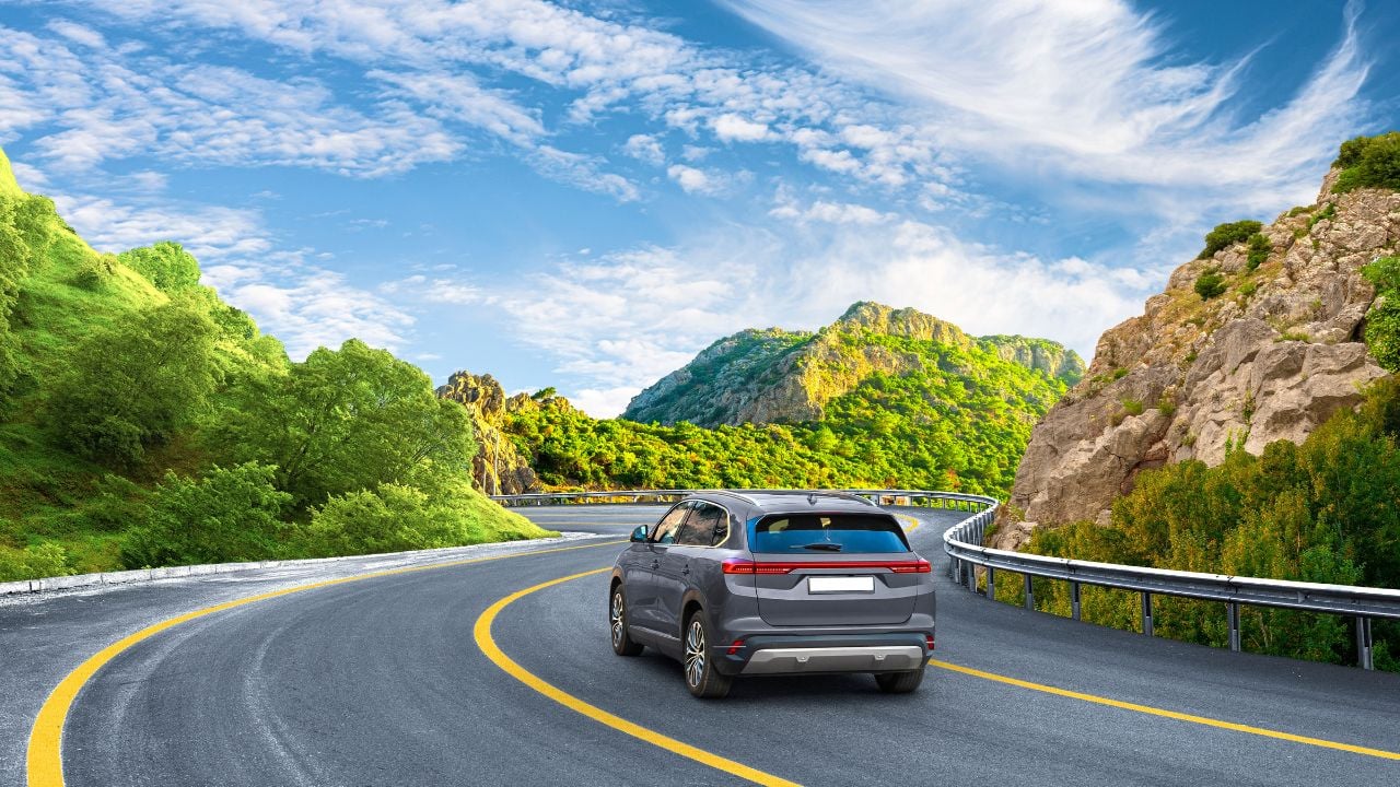 Electric car drive on nature road between green mountains in summer. Nature landscape on highway for summer vacation travel. Mountain road view on beautiful nature trip in Europe. car drive on highway