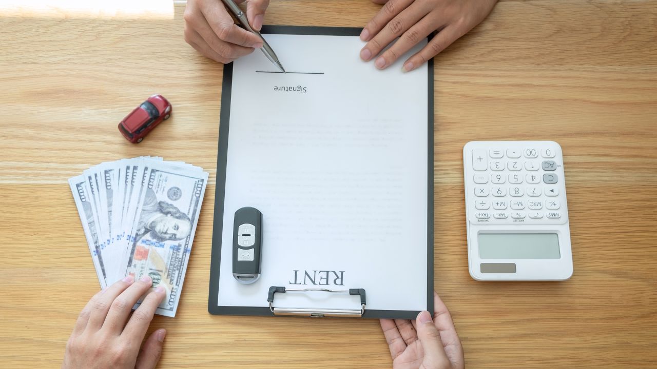 Car rental and Insurance concept, Young salesman receiving money and giving car's key to customer after sign agreement contract with approved good deal for rent or purchase.