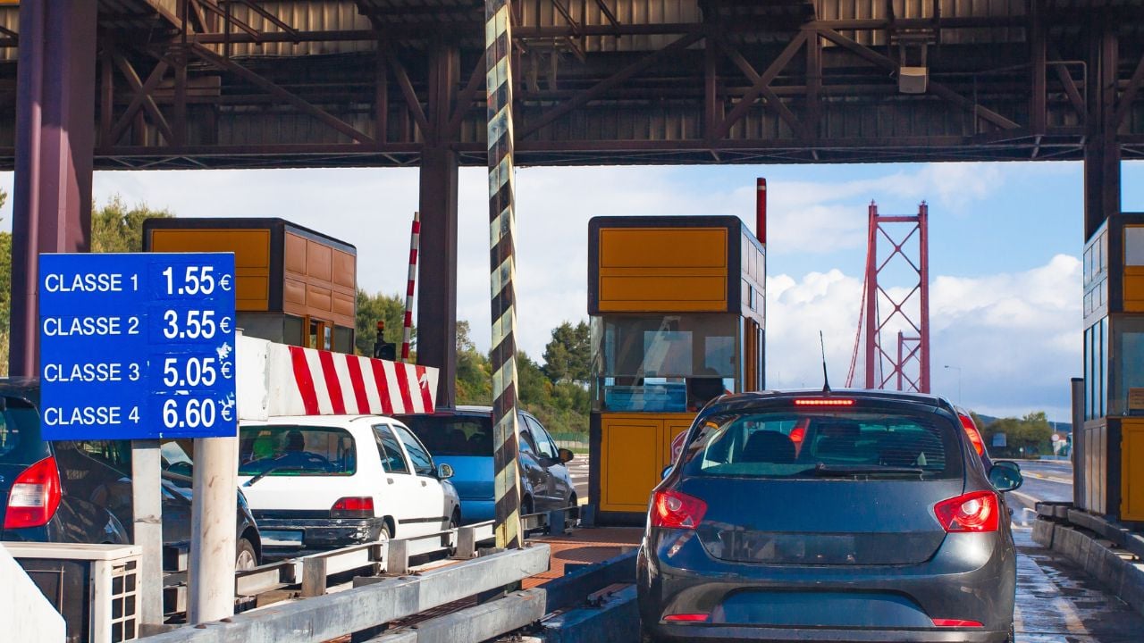 Toll station in Portugal. Cars crossing toll road gates at sunny summer day