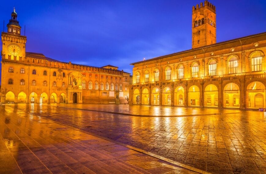 View of Main Square (Piazza Maggiore) under clear blu sky with Palazzo d'Accursio (left) and Palazzo Podestà (right), Bologna, Italy