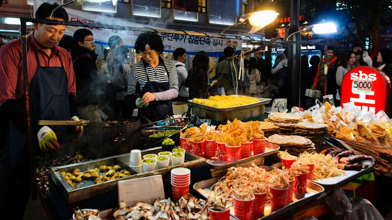 Korean street food in Seoul city, Myeong-dong Shopping Street. Seoul shopping center, night market and bazaar. Korean crackers. Seoul, South Korea - 10.31.2011.