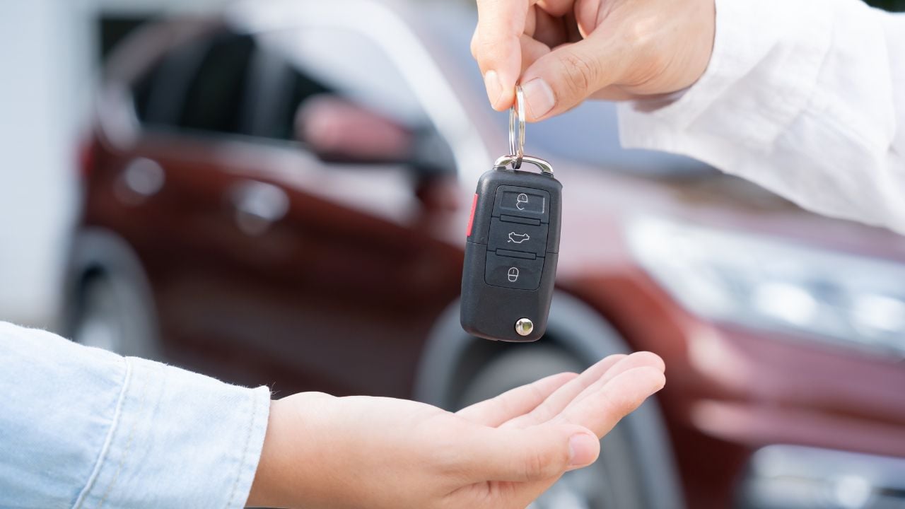 Car keys being handed over during a vehicle rental or purchase agreement
