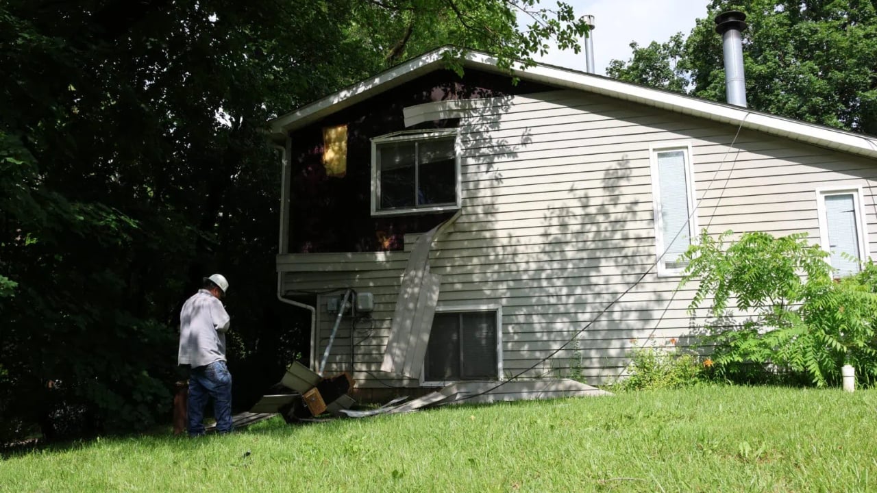 Garbage truck catches on overhead wires, trapping driver and damaging home in Ingleside