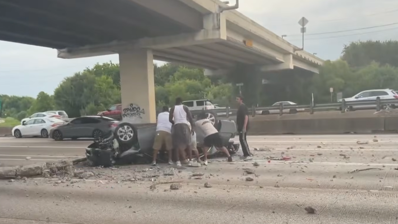 people rescue drivers from crashed car