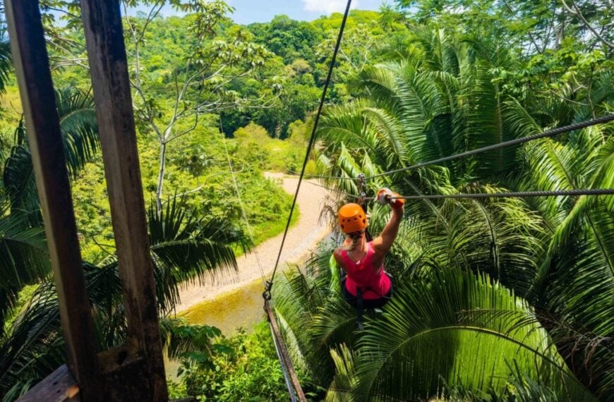 a woman ziplines through the belize jungle