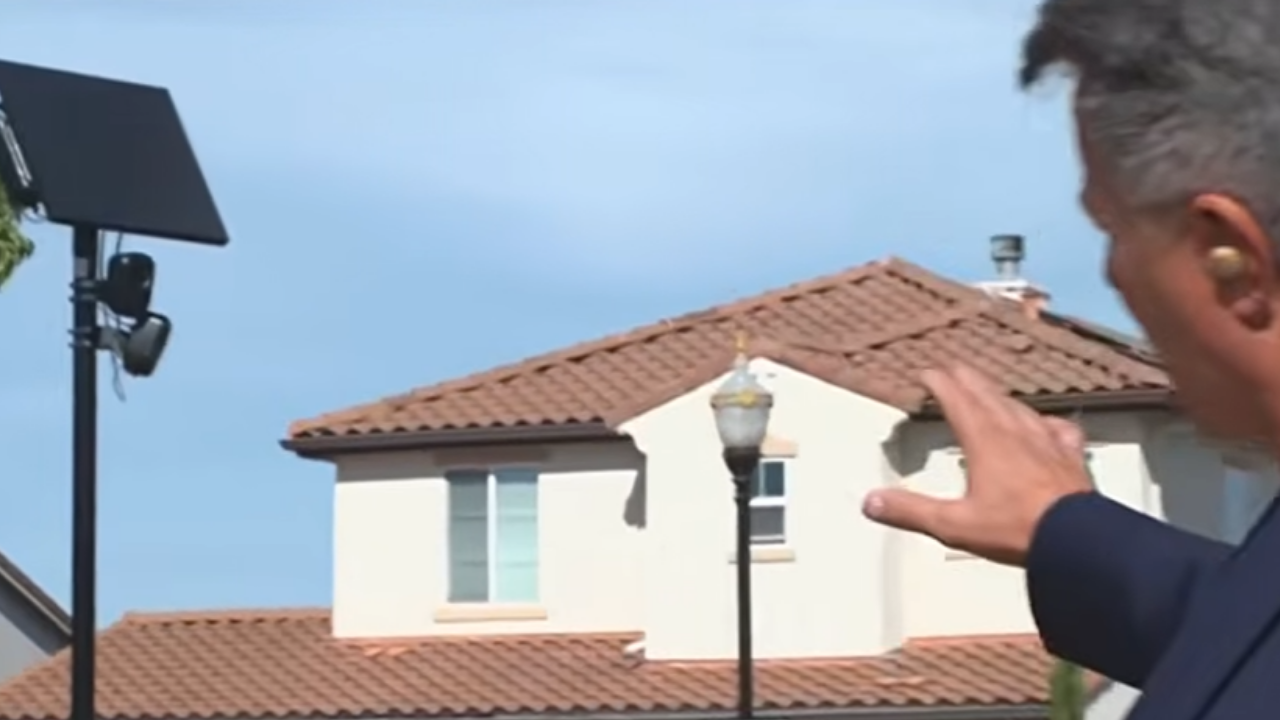 Man points out a home near a Flock camera