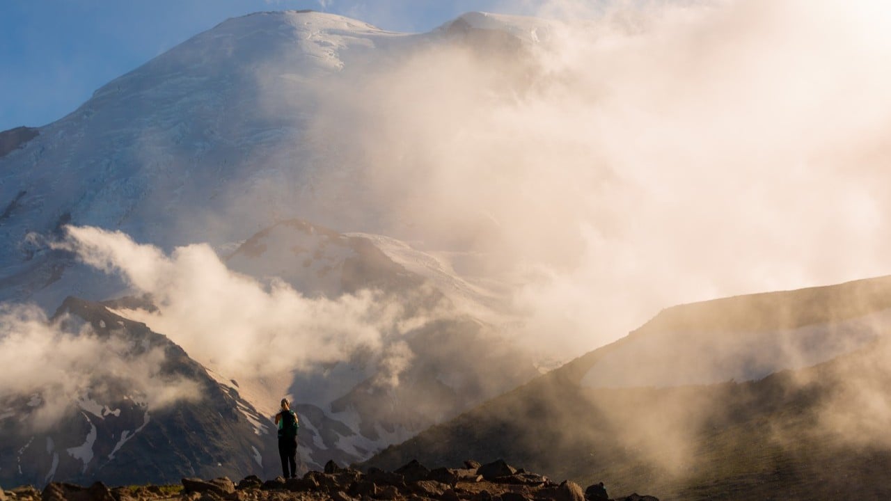 a hiker in front of mount rainier