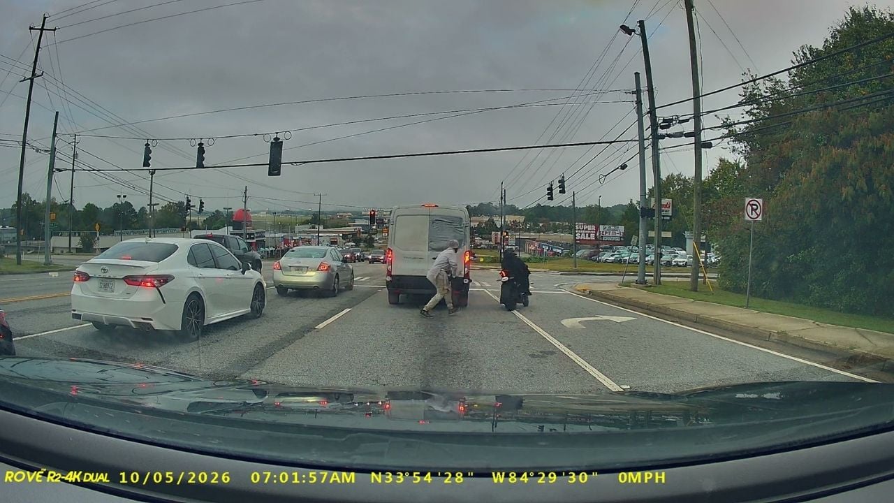 Crazy man runs at motorcyclist at traffic lights