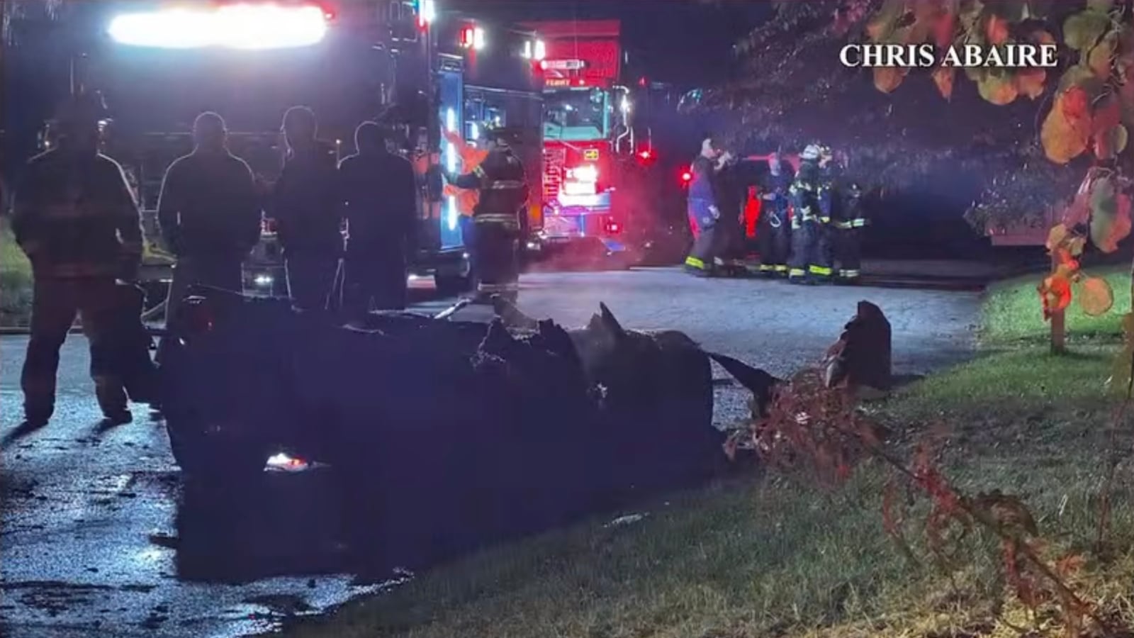 burned corvette surrounded by police and fire crews