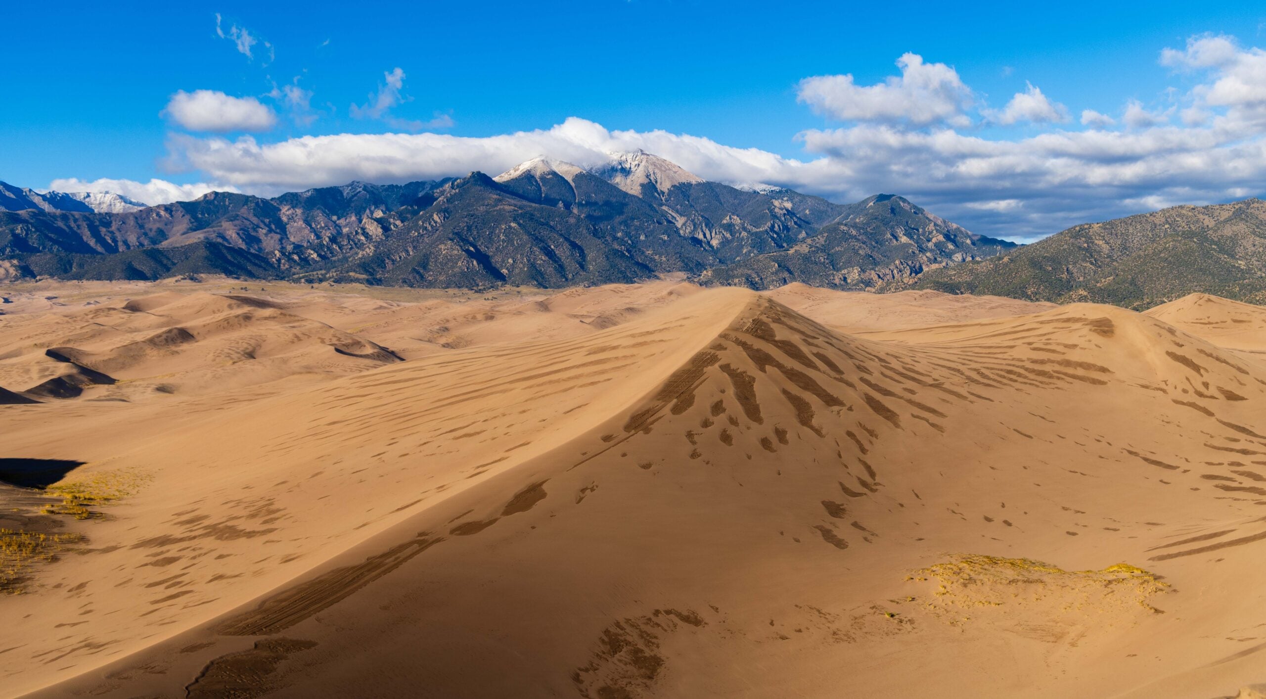 great sand dunes national park wtih snow capped mountains in the background
